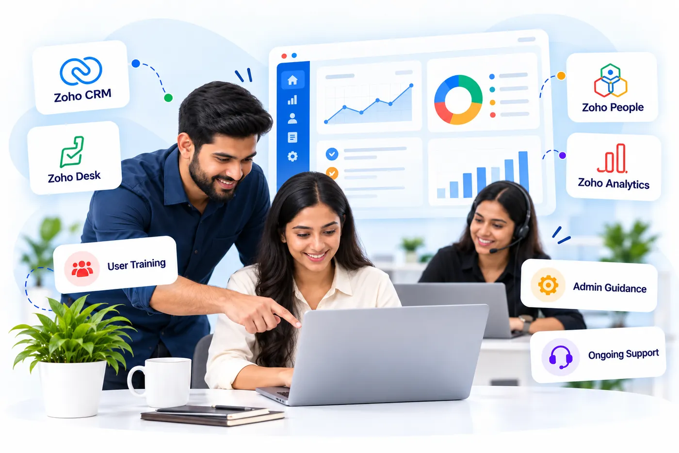 A trainer showing a colleague how to use Zoho on a laptop, with a support specialist wearing a headset in the background
